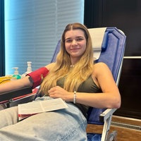 Eine junge Frau liegt auf einer blauen Liege und spendet Blut