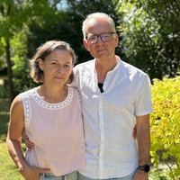 Ein älteres Paar, eine Frau und ein Mann posieren für die Kamera. Der Mann hat seinen Arm um die Frau gelegt.