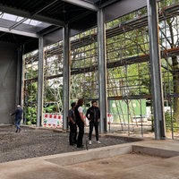 Fünf Personen stehen in einer Halle die sich im Aufbau befindet