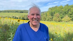 Mann steht auf der Blumenwiese 