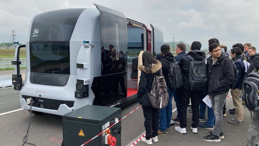 Personen steigen in ein voll automatisiertes Fahrzeug