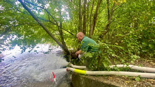 Wasser aus Wasserschläuchen spritzt in den See