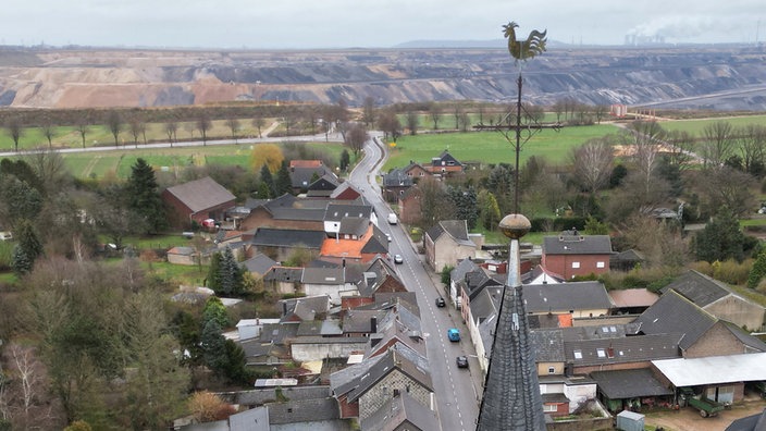 Die Ortschaft Keyenberg aus der Luft mit dem Tagebau am Horizont