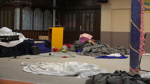 Stoffe, Kabel und Mikrofone liegen auf dem Boden des Saals der Sikh-Gemeinde in Moers