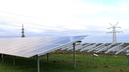 Fertige Photovoltaikanlage im Vordergrund. Rahmen und Gestelle für Photovoltaikanlage im Hintergrund