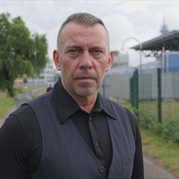 Zeuge Robert K. steht auf einem Weg vor dem Oberlandesgericht Düsseldorf.
