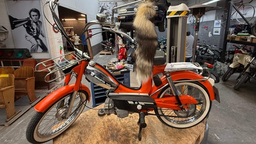 Ein rotes Moped: Modell Sparta Buddy von 1976 mit einem Fuchsschwanz in der Werkstatt von Holger Rick