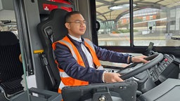Steven Schiwy sitzt in einem Bus des Schienenersatzverkehrs in Leverkusen.