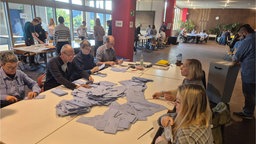 Das Bild zeigt mehrere Wahlhelfende beim Auszählen der Stimmen.