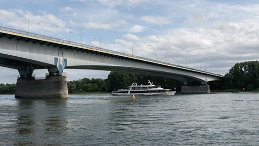 Ein Schiff auf dem Rhein unterquert die Konrad-Adenauer-Brücke (Südbrücke).