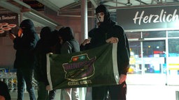Personen halten ein Banner hoch. Auf diesem steht "Illegal Nights"