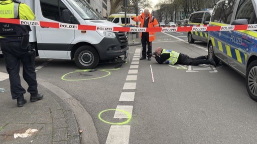 Ein Polizist liegt auf dem Boden und fotografiert die Spuren des Unfalls 