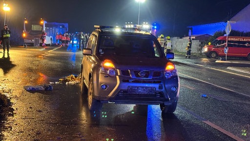 Unfallwagen. Im Hintergrund Einsatzkräfte