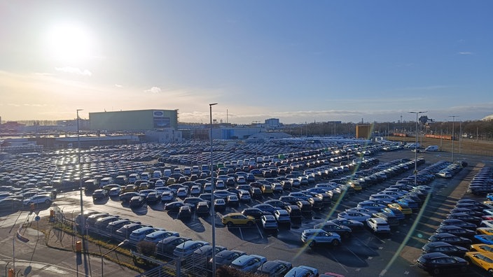 Der Blick über geparkte Autos auf das Ford Westgelände 