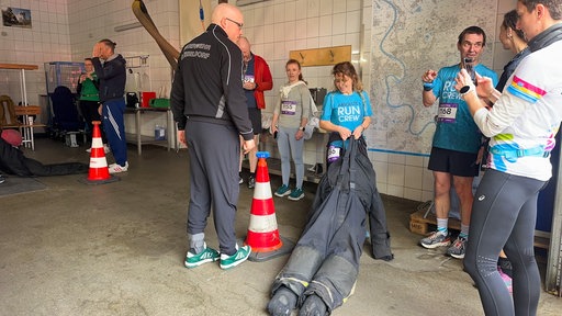 Emy Hetemi zieht auf der Feuerwehrwache eine Puppe beim Urban Trail in Düsseldorf