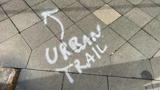 Eine Wegmarkierung auf dem Boden beim Urban Trail in Düsseldorf