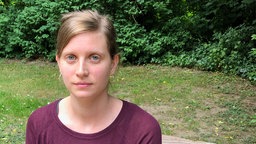 Eine Frau schaut in die Kamera.