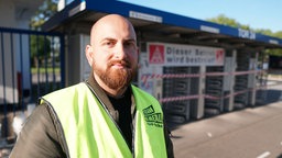 Vural Köksal steht vor einem Werkstor von Ford.