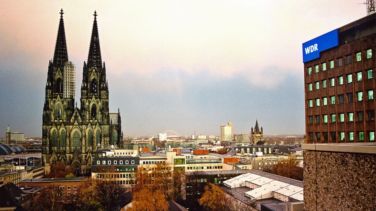Der Kölner Dom unter dem Abendhimmel und das Archivhaus des WDR