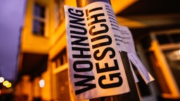 Ein Zettel mit der Aufschrift "Wohnung gesucht" hängt an einer Laterne