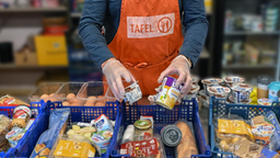 ein Tafel Mitarbeiter füllt Körbe mit Lebensmitteln