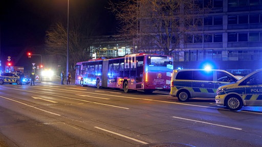 Ein Bus steht mit Polizeiautos am Straßenrand