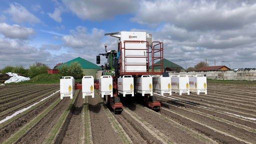 Ein Traktor fährt über ein Feld. Hinten am Fahrzeug sind weiße Roboter-Module zu sehen, aus welchen der Laser gegen Unkraut ankämpft.