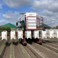 Ein Traktor fährt über ein Feld. Hinten am Fahrzeug sind weiße Roboter-Module zu sehen, aus welchen der Laser gegen Unkraut ankämpft.