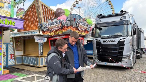 Der Platzmeister und seine Kollegin beim Aufbau der Cranger Kirmes
