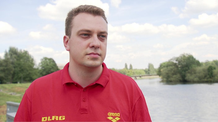 Auf dem Bild sieht man Frederik Mulder von der DLRG Essen draußen vor einem Kanal stehen.