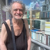 Wolfgang Jöst, ein älterer Mann mit grauen Locken, steht vor seiner Buchandlung.