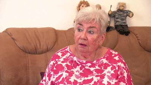 Ursula Schubert aus Essen sitzt auf dem Sofa in ihrer Wohnung