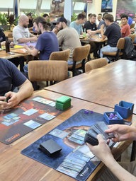 Zwei Menschen an einem Tisch mit Spielkarten in den Händen