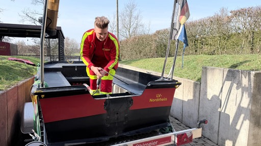 Eine Ehrenamtliche der DLRG steht auf dem Boot ohne Motor.