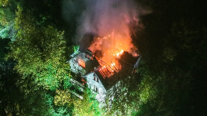 Helle Flammen auf dem Dach eines großen Gebäudes von oben