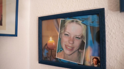 Ein Bilderrahmen an der Wand, daran hängt das Foto der vermissten Bianca Blömeke, einer jungen blonden Frau