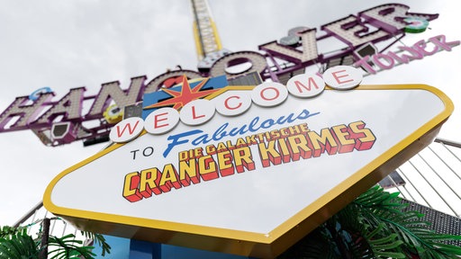 Eine große, bunte Anzeigetafel mit der Aufschrift "Welcome to fabolous - die galaktische Cranger Kirmes"
