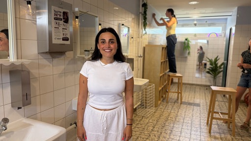 Eine Lehrerin steht in einer Mädchentoilette