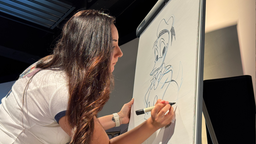 Die Disneyzeichnerin Cynthia C. Pineda zeichnet an einer Leinwand die Figur Donald Duck.