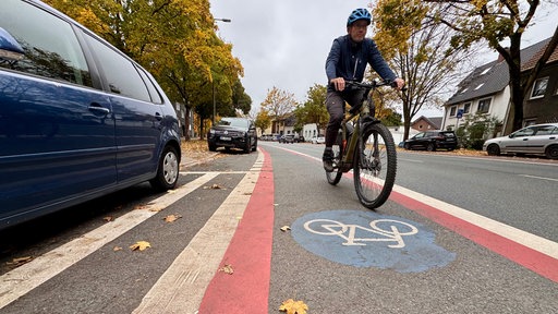 Ein Mann fährt auf dem gekennzeichneten Radweg mit seinem Fahrrad.