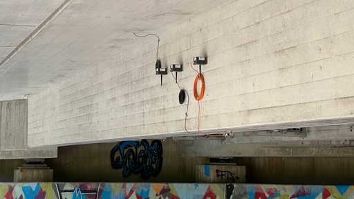 Sensorenteile sind unter einer Brücke am Beton befestigt.