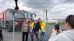 Vier Menschen stehen vor einem Löschfahrzeug am Dortmunder Flughafen.