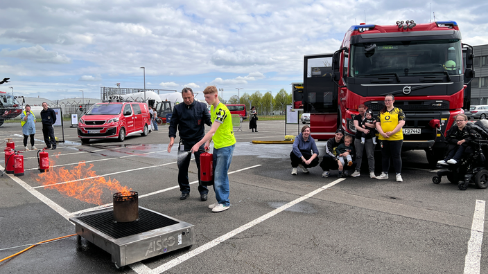 Ein junger Mann löscht ein Feuer am Dortmunder Flughafen.