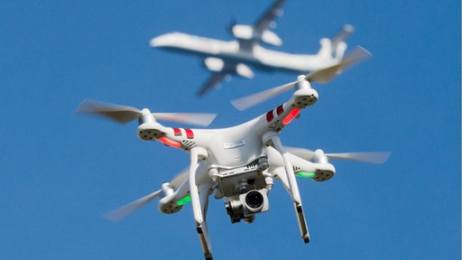 Eine Drohne fliegt vor einem Passagierflugzeug