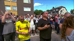 Mehrere Menschen stehen auf der Straße und warten auf die Sprengung