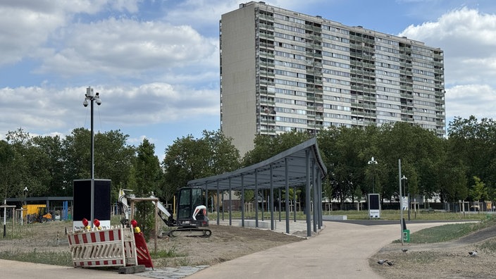 Hochhaus der "Weißen Riesen" in der Nähe der Trinkhalle, im Vordergrund befindet sich ein Park im Aufbau