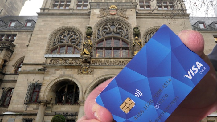 Eine Bezahlkarte im Vordergrund und das Duisburger Rathaus im Hintergrund