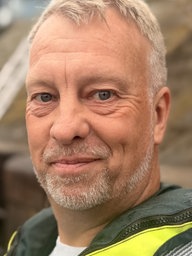Ein Mann in Warmweste steht an einem Hafenbecken