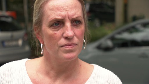 Eine blonde Frau schaut ernst in die Kamera