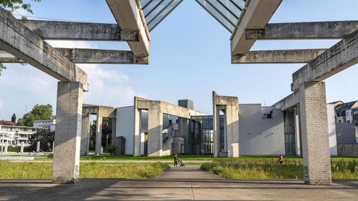Die Duisburger Synagoge. Im Vordergrund grüner Rasen, im Hintergrund blauer Himmel.